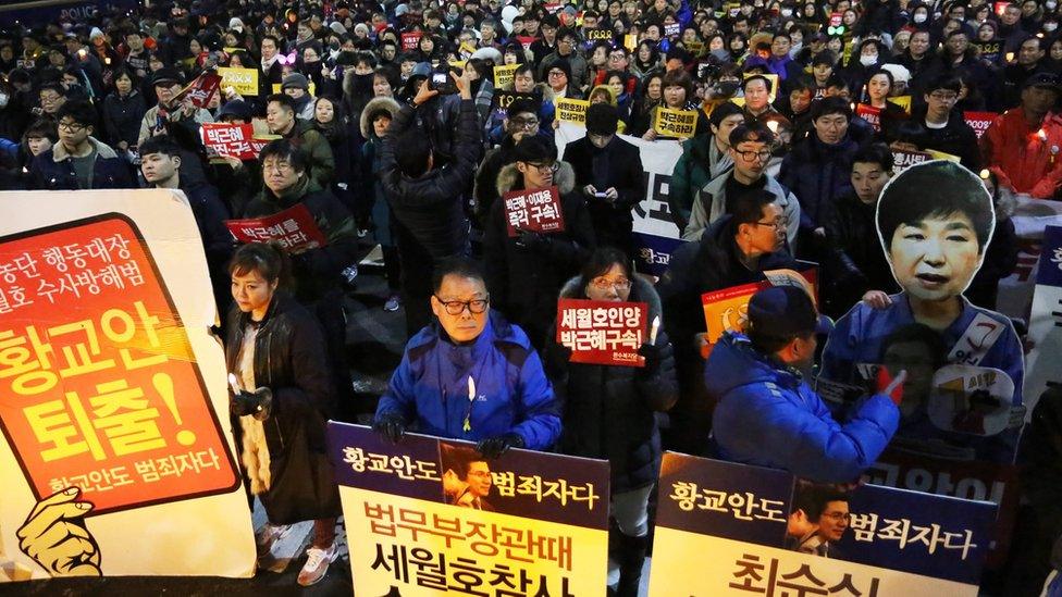 South Koreans march carrying placards reading "Park Geun-Hye and Prime Minister Hwang Kyo-ahn Out"