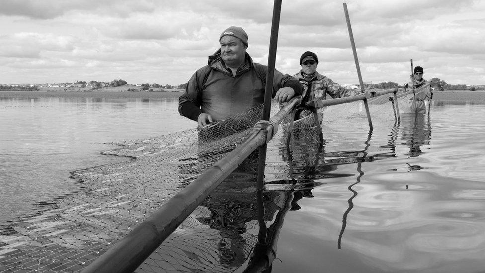 Fishermen in the water, black and white photo