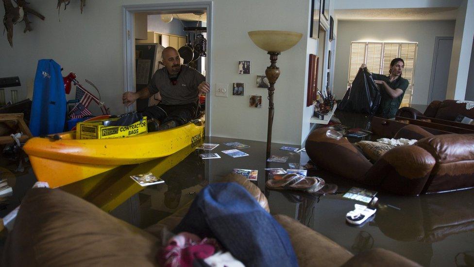 arry Koser Jr. (L) and his son Matthew look for important papers and heirlooms inside Larry Koser Sr."s house after it was flooded by heavy rains from Hurricane Harvey August 29, 2017 in the Bear Creek neighborhood of west Houston, Texas.