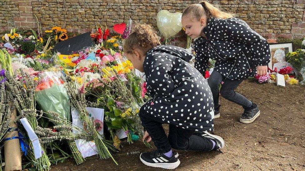 Two girls laying flowers