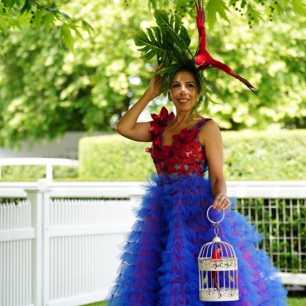 A racegoer wearing a parrot-themed hat and dress