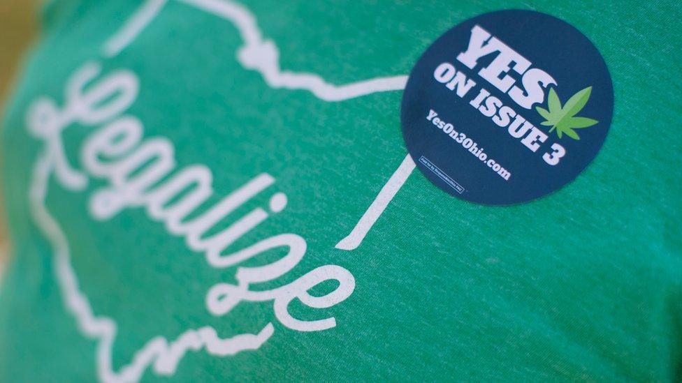 Michael McGovern, a representative from ResponsibleOhio, a pro-marijuana legalization group, wears a sticker during a promotional tour stop at Miami University, Friday, Oct. 23, 2015, in Oxford, Ohio.