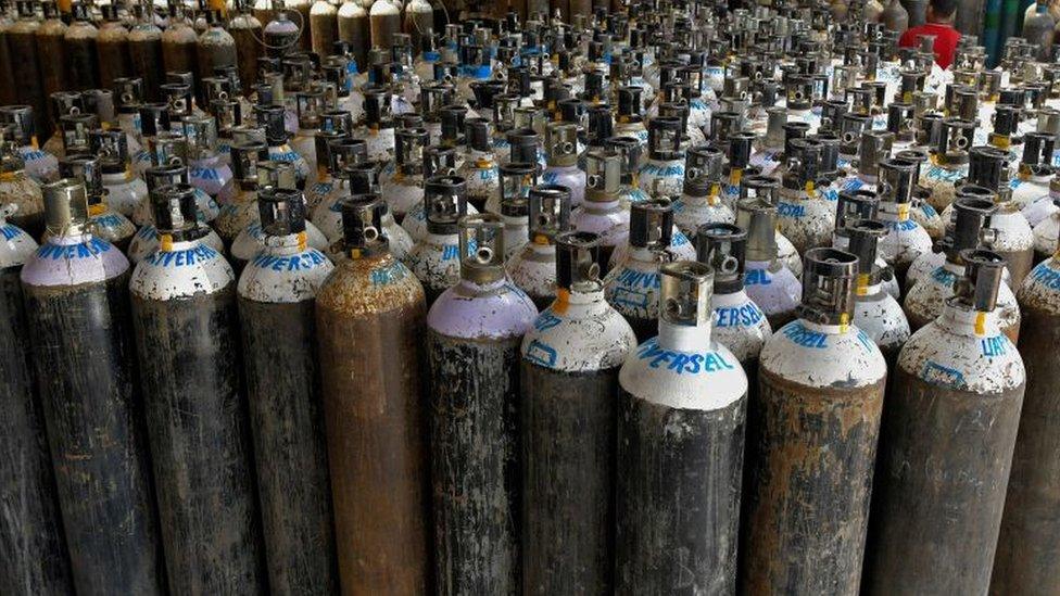 Workers are seen sorting oxygen cylinders that are being used for Covid-19 coronavirus patients before dispatching them to hospitals at a facility in Bangalore on April 19, 2021.