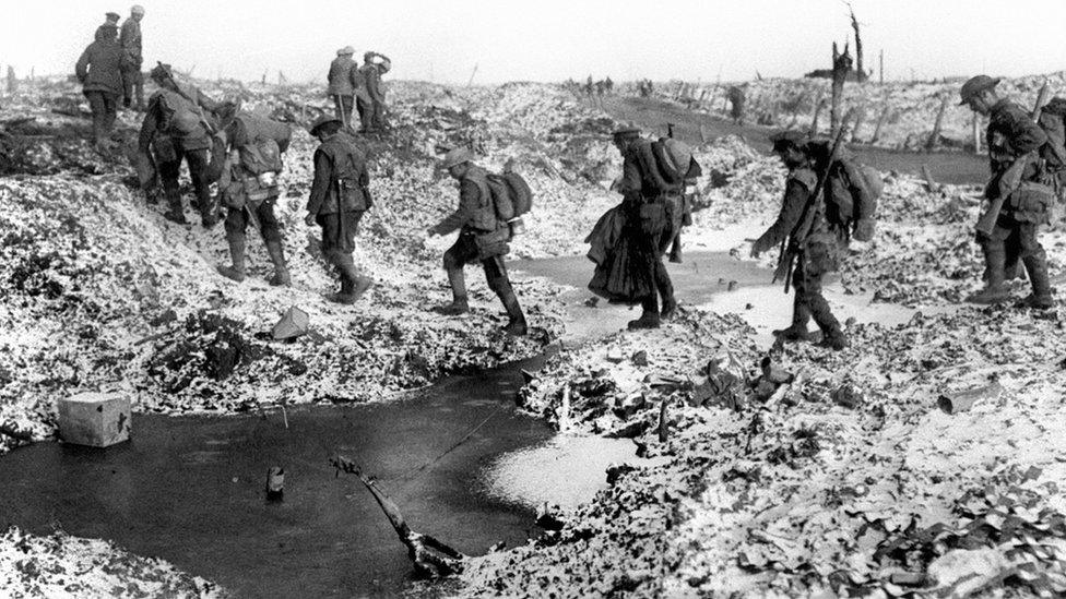 British soldiers negotiating a shell-cratered, Winter landscape along the River Somme in late 1916 after the close of the Allied offensive