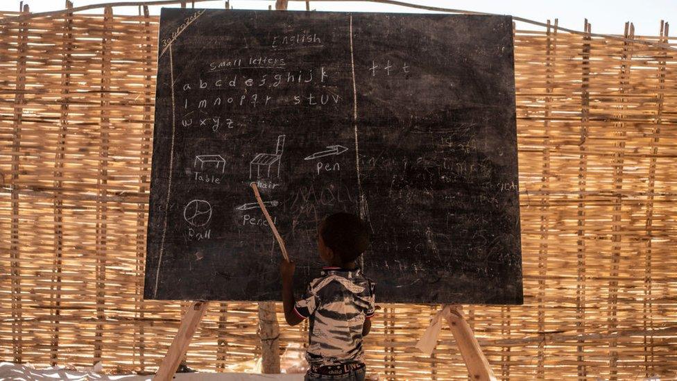 A child reads some English words during his class at the school inside the Um Rakuba camp on January 8, 2021 in Um Rakuba, Sudan