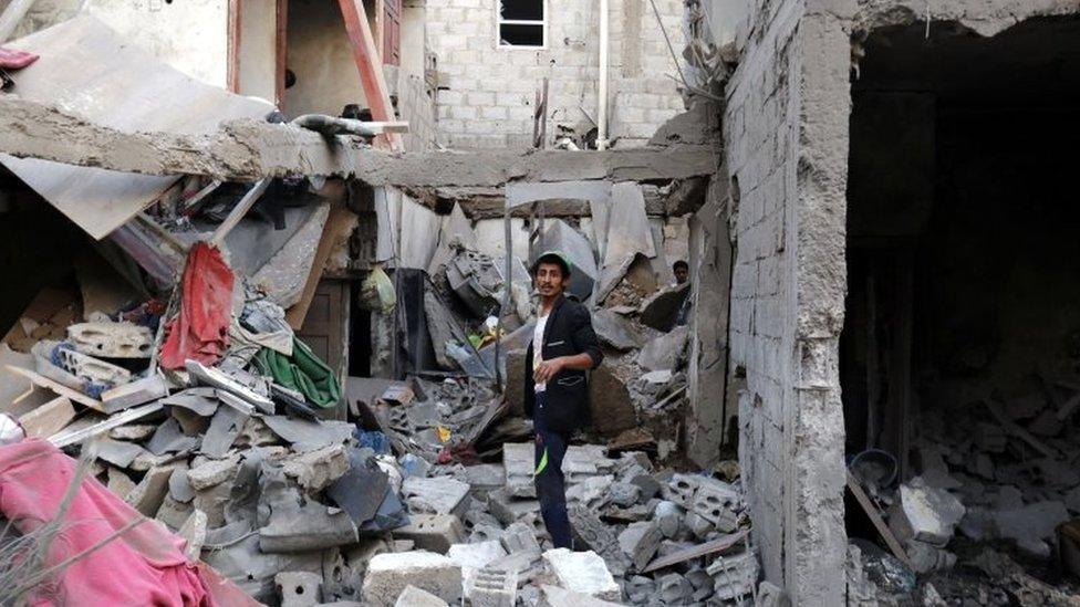 A man among rubble after an alleged Saudi-led airstrike in Yemen