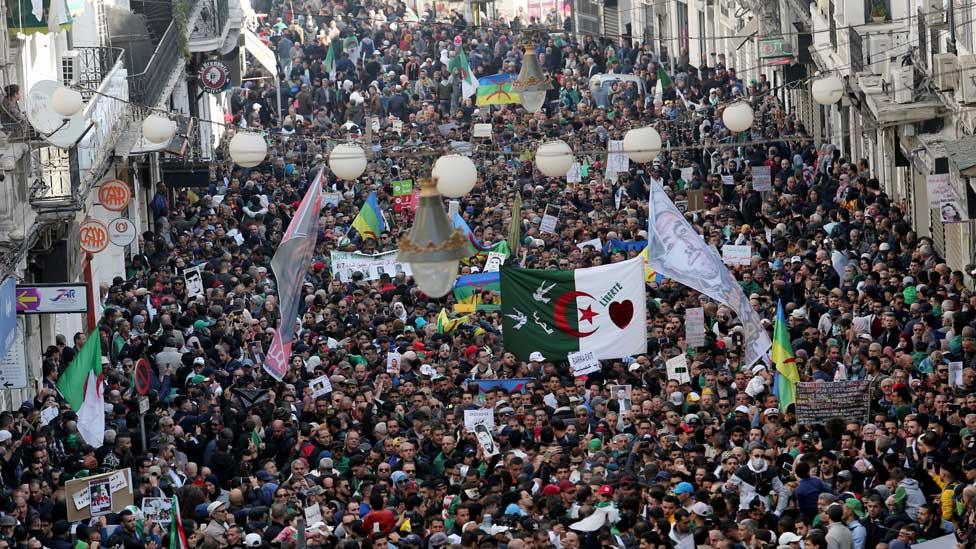 Algerians carry banners and flags during a demonstration to mark the first anniversary of protests that ousted President Abdelaziz Bouteflika, in Algiers, Algeria February 22, 2020.