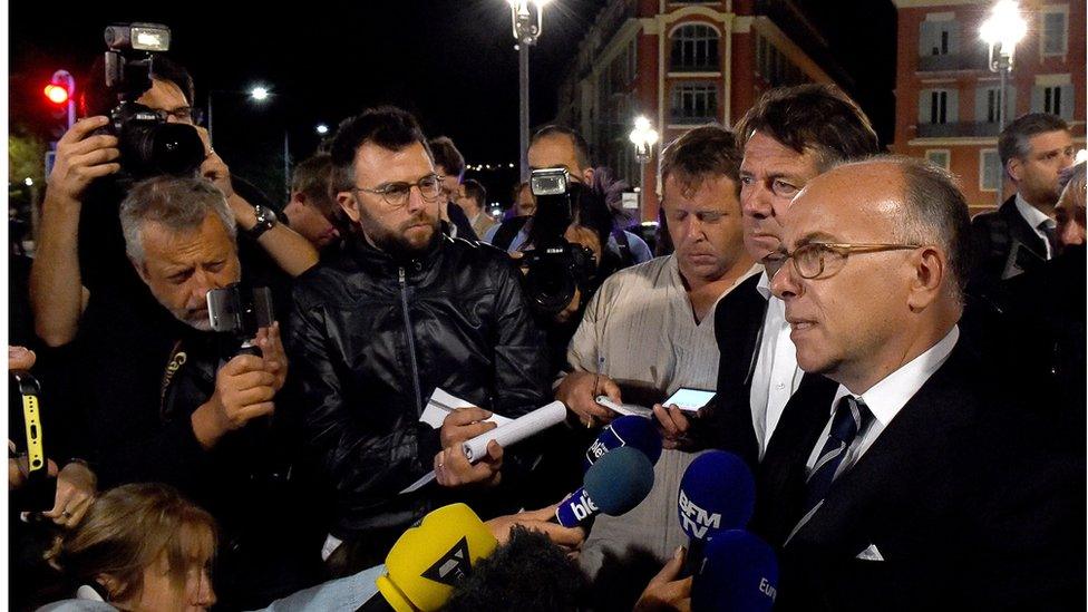 French Interior Minister Bernard Cazeneuve (right) talks to reporters