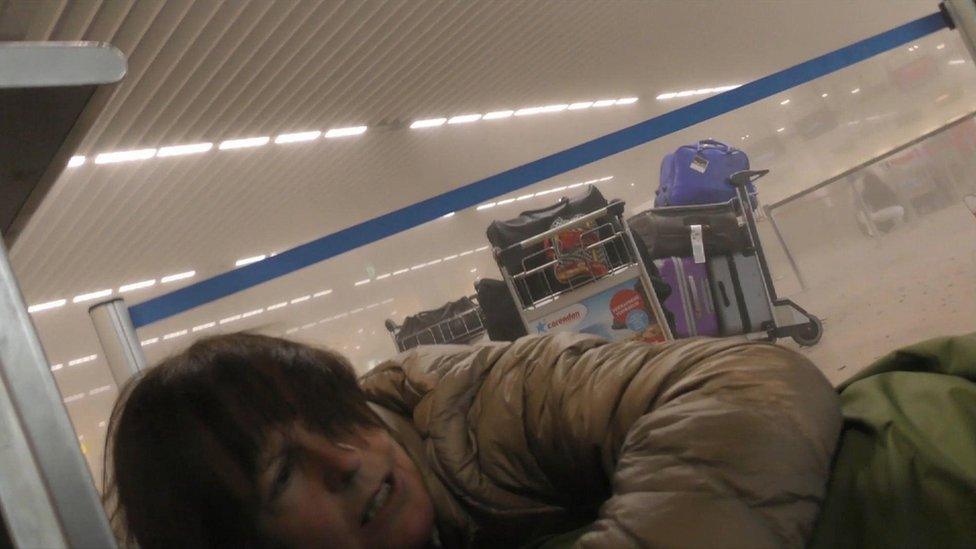 Unidentified traveller lies on the ground in a smoke filled terminal at Brussels Airport