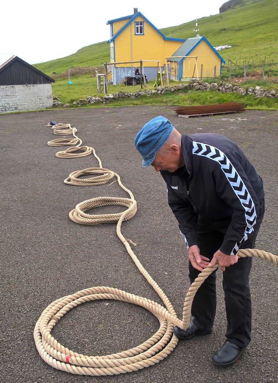 Oscar Joensen lays out the long rope needed for the climb before the village school