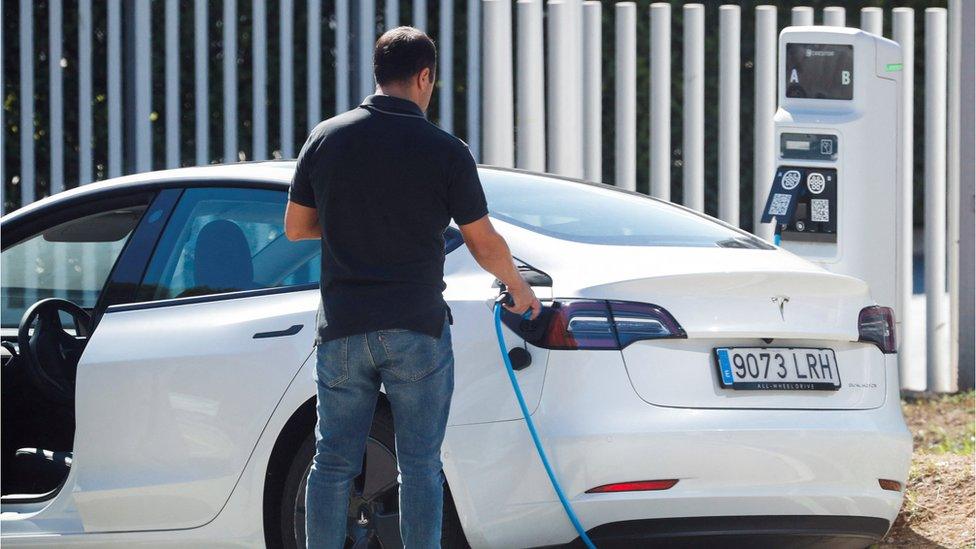 Person charging their electric vehicle