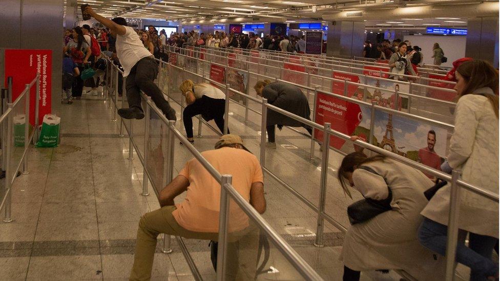 people duck under and climb over barriers at the check in desks of the airport, June 28 2016