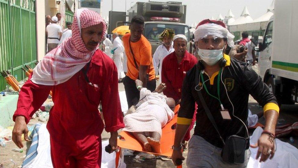 Saudi emergency personnel and Hajj pilgrims carry a wounded person at the site where hundreds were killed and wounded in a stampede in Mina