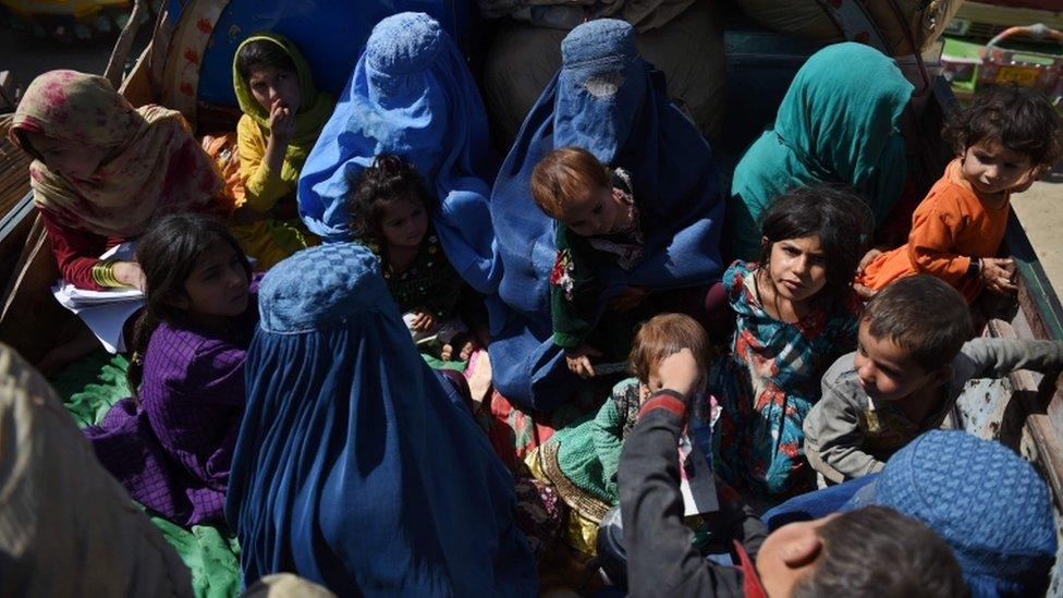 Afghan women and children sit in a truck