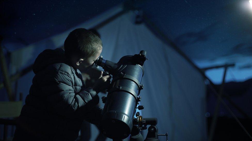 Child with telescope.