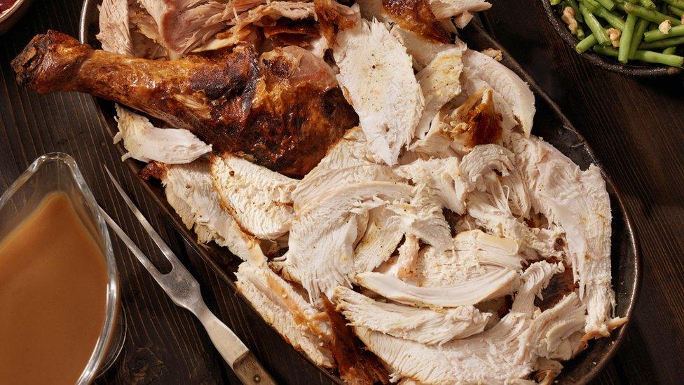 Turkey carved on a silver plate laid on a wooden table