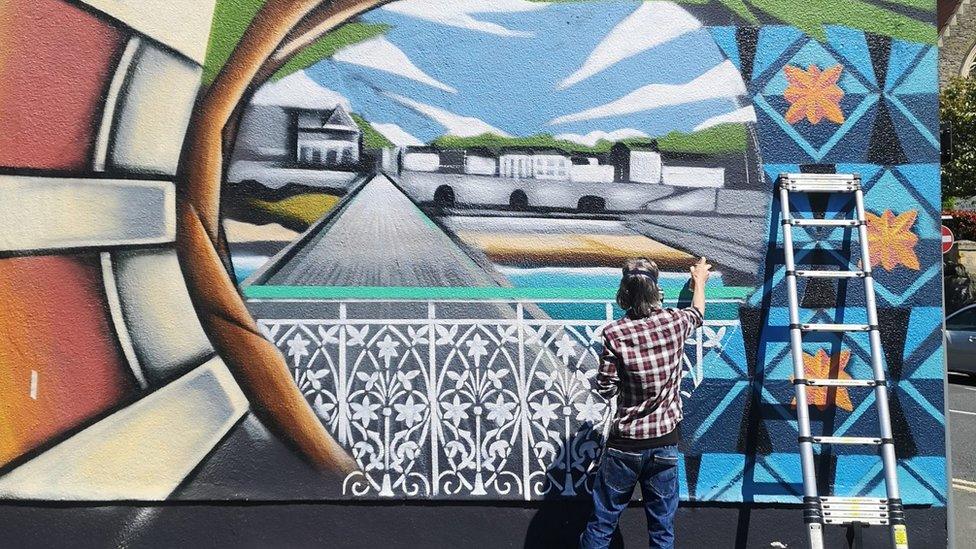 A man painting a mural