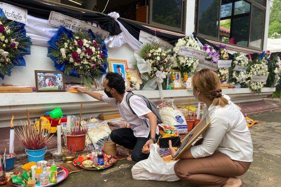 Suphan Sangsri and his wife Rattana Malapim place gifts for their four-year-old son Thanakorn Karadee