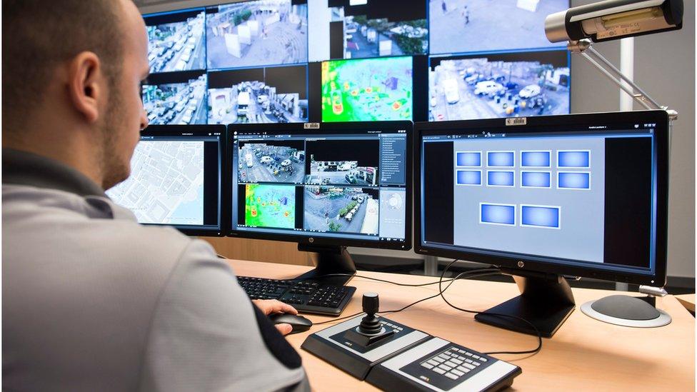 policeman watching surveillance monitors in Geneva