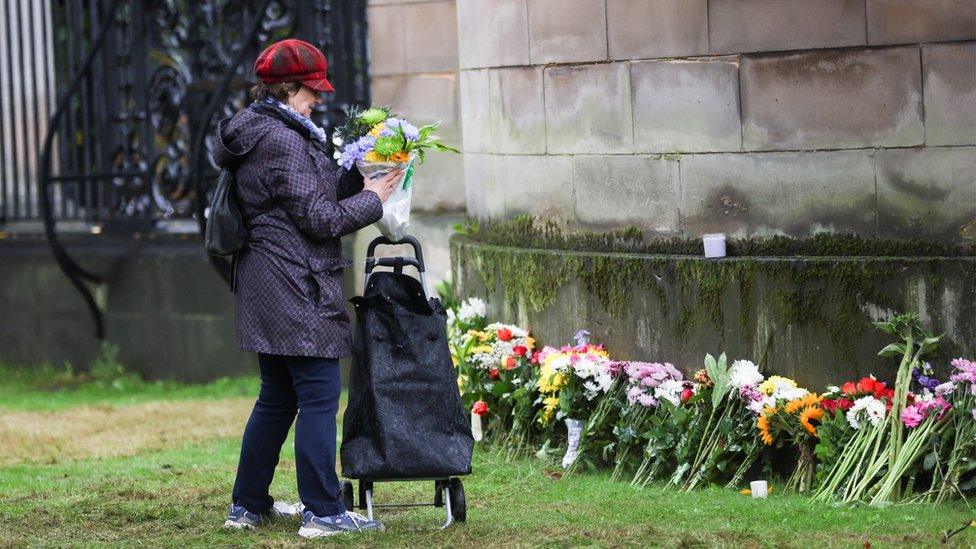 Woman laying flowers at Holyrood