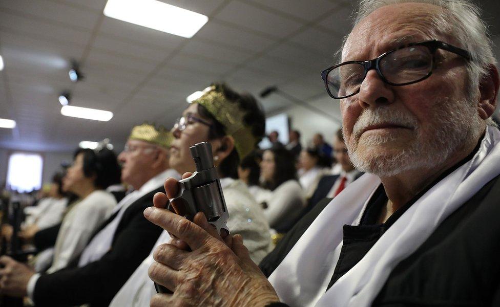 A man holds a pistol during a ceremony at the World Peace and Unification Sanctuary