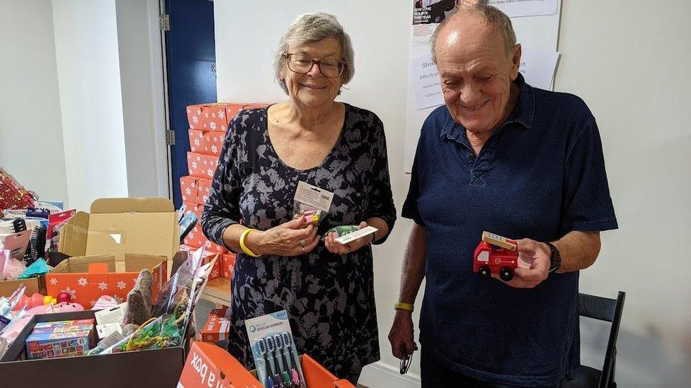 Viv Warren and Bill Webb holding toys for the boxes.