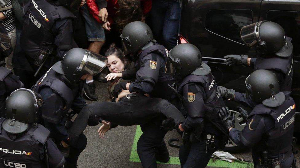 Spanish National riot police evict a young woman during clashes between the people gathered outside the Ramon Llull school and police forces in Barcelona, Catalonia, on 01 October 2017.