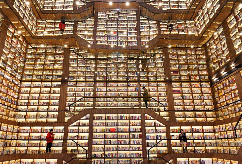 People stand and read books in a giant bookstore