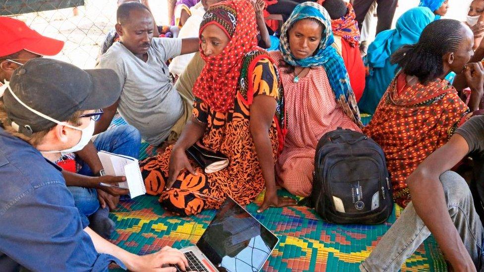 An Ethiopian refugee who has fled the Tigray conflict, sends a message to her mother in Ethiopia through members of the International Committee of the Red Cross (ICRC) at a transit centre in Sudan's border town of Hamdayit on November 27, 2020.