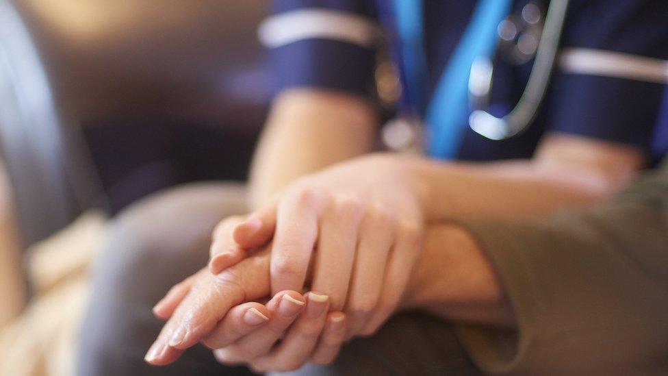 Nurse holding a patient's hand