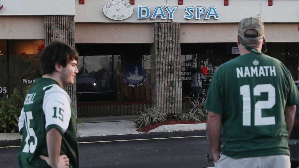 New York Jets fans stand outside the day spa