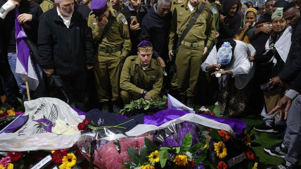 Soldiers and family members gather next to the grave of Israeli soldier of Ethiopian origin staff sergeant Birhanu Kassie in Mount Herzl military cemetery in Jerusalem