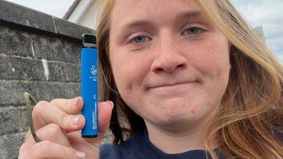 Woman holding blue vape