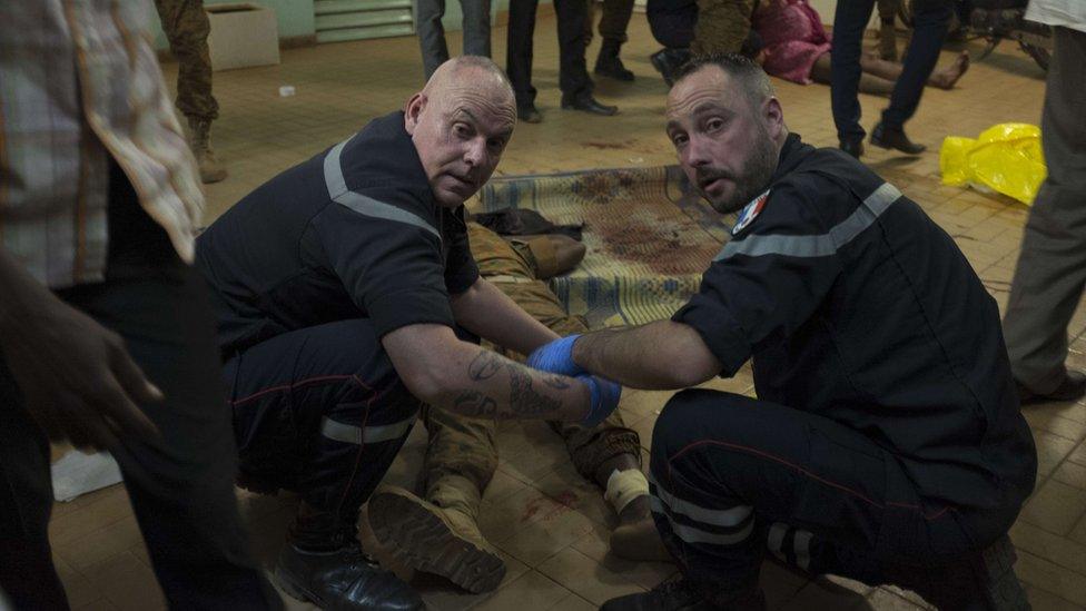 French gendarmes tend to wounded people in the surrounding of the hotel Splendid and the cafÃ© Cappuccino during the attack on January 15, 2016.