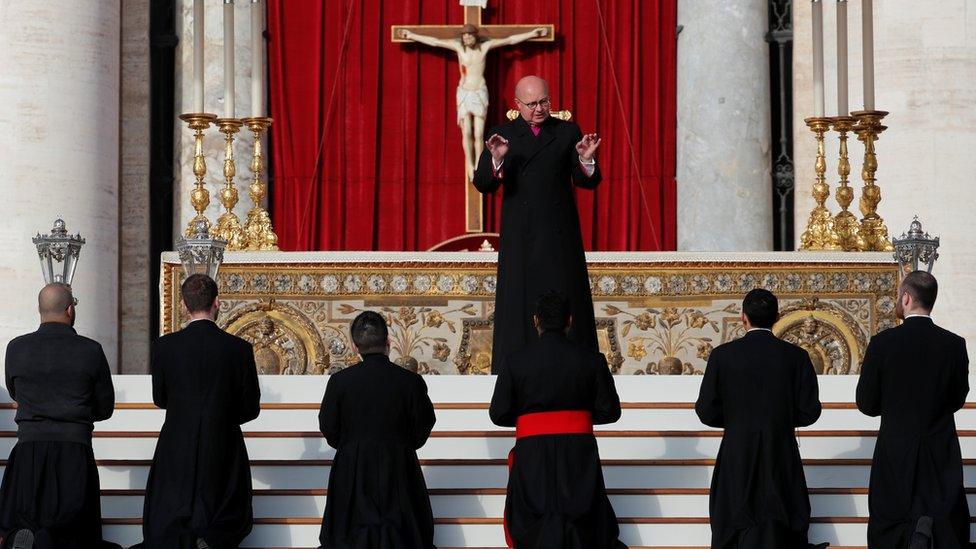 A priest giving instructions at the Vatican