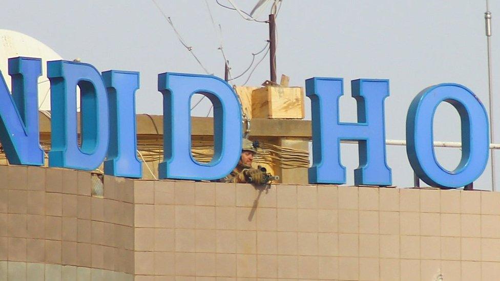 A foreign soldier on a rooftop in Ouagadougou, 16 soldiers