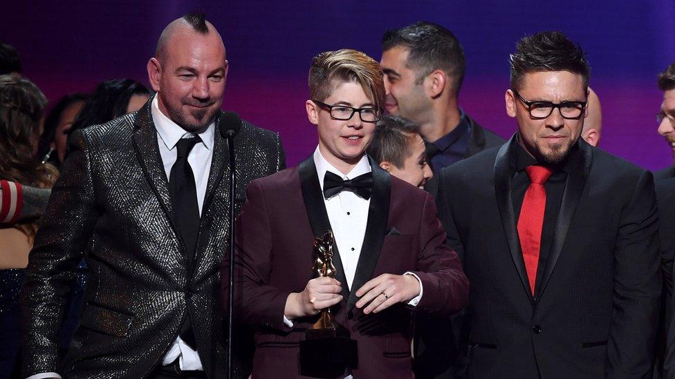 Bree Mills (centre) accepts the award for Movie of the Year during the 2018 Adult Video News Awards, together with co-director Craven Moorehead (left) and producer Billy Visual (right)