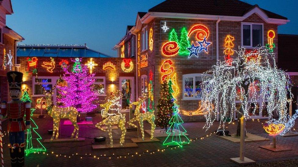 The outside of a house heavily decorated with Christmas lights.