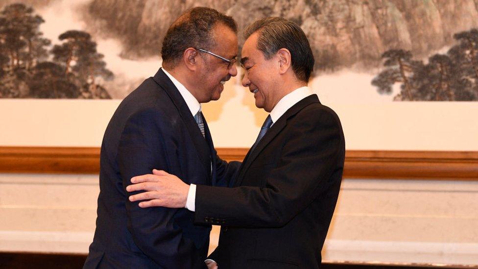 Tedros Adhanom, Director General of the World Health Organization, (L) shakes hands with Chinese State Councilor and Foreign Minister Wang Yi