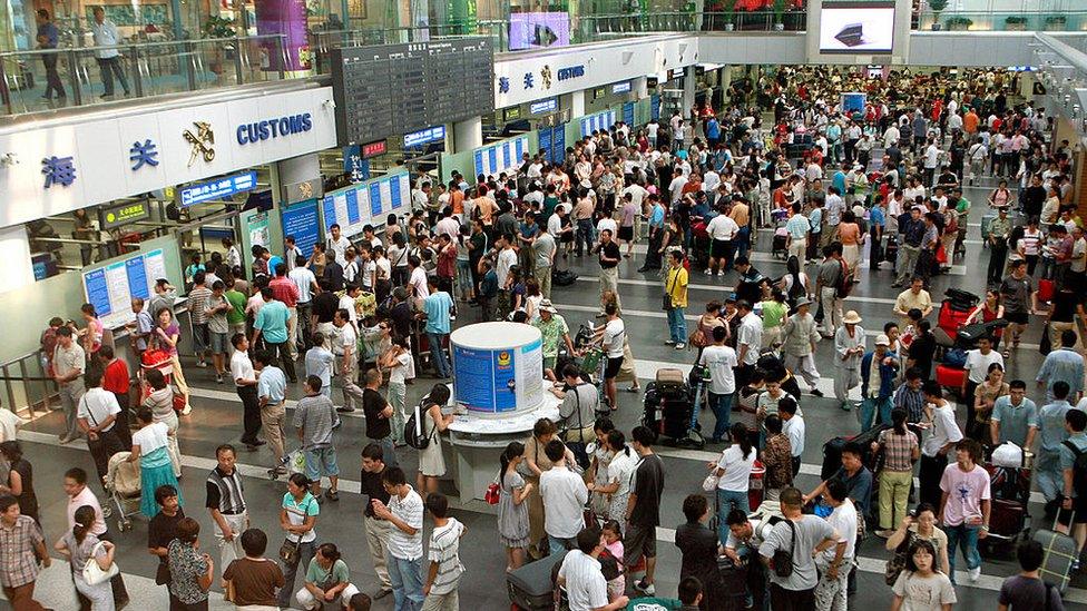 Travellers crowd the check-in area of Beijing's Capital International Airport