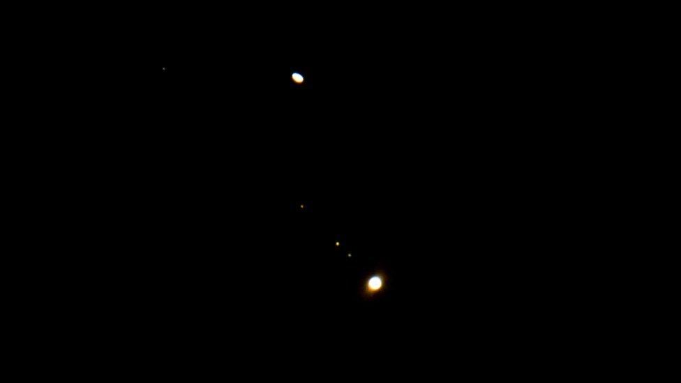 Jupiter, with it's moons, and Saturn (top) are seen in close proximity to each other.