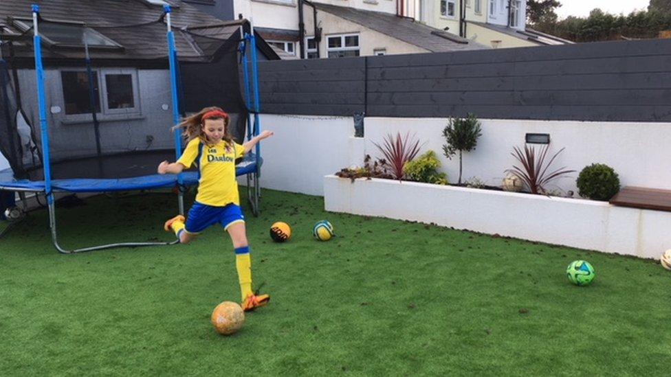 Lucy Bunn playing football in her garden