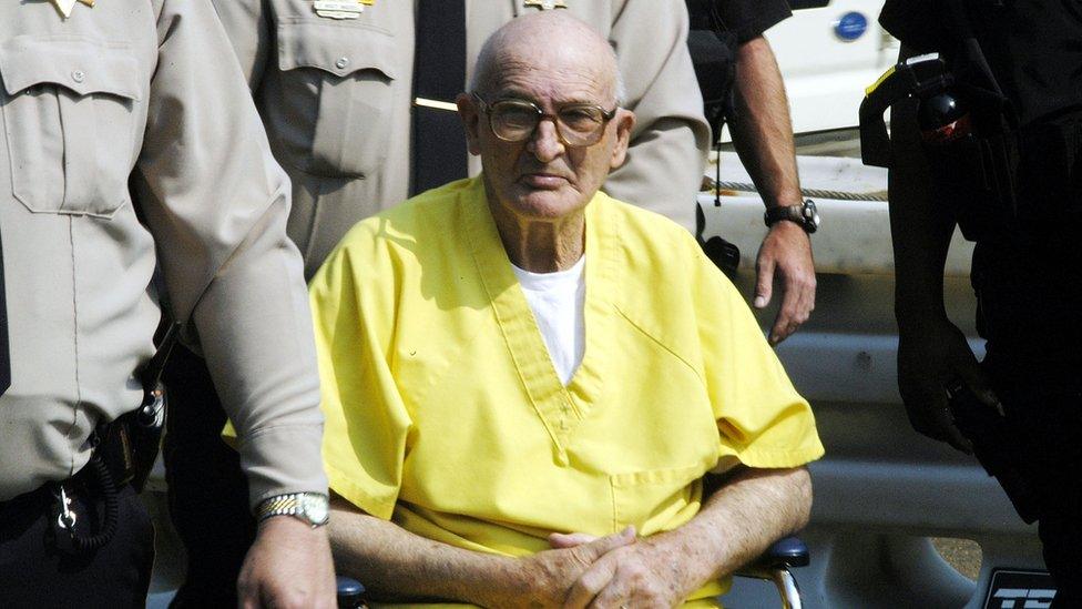 Killen, seen in a yellow jumpsuit, is wheeled in