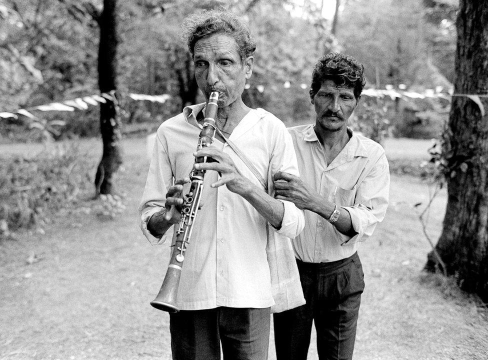 Blind musician being led at a local feast, Loutolim, Goa, 1994