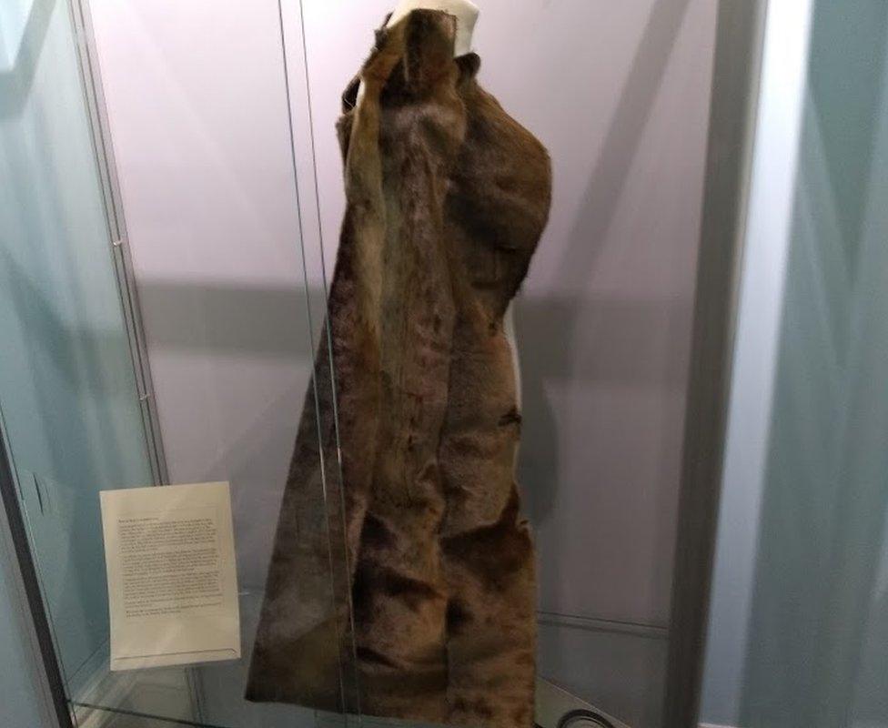 Fur coat hanging on a mannequin in a display cabinet