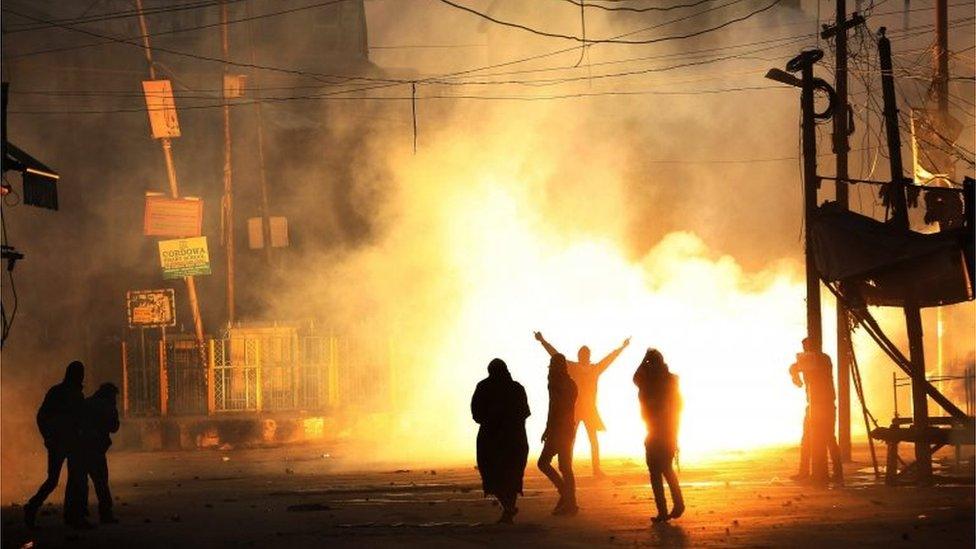 Kashmiri Muslim protesters shout slogans amid exploding smoke canisters fired by the Indian security forces during a protest in downtown of Srinagar, the summer capital of Indian Kashmir, 04 December 2015