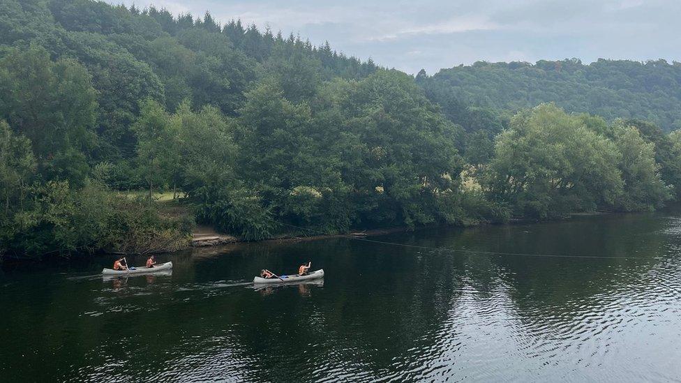 Two canoe boats in the background of a picture of a lake