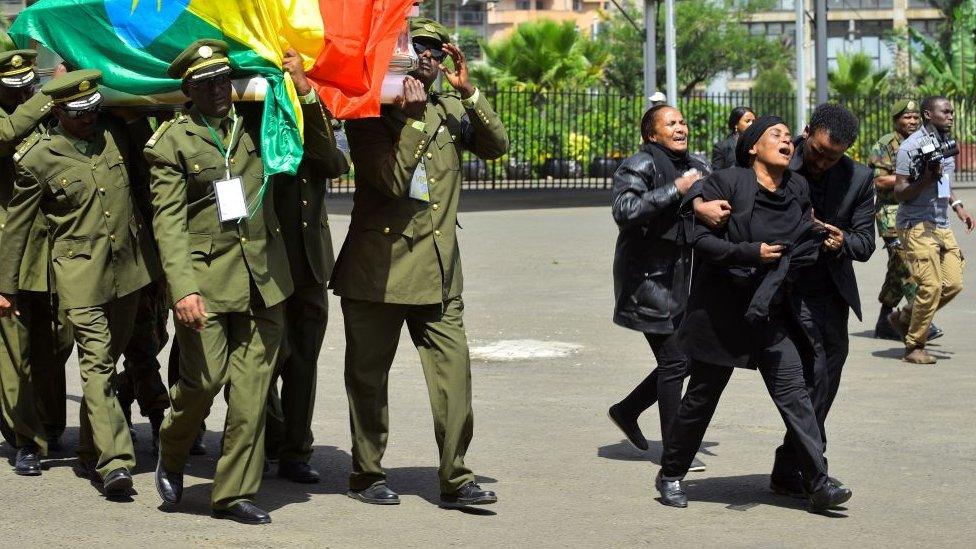 Woman weeps alongside coffins at the memorial service in Addis Ababa