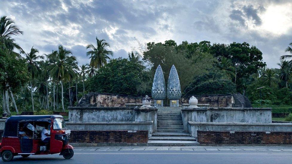 This picture taken on April 24, 2022 shows an autorickshaw driving past a museum constructed in memory of Sri Lankan Prime Minister Mahinda Rajapaksa's father and mother at Medamulana in Hambantota