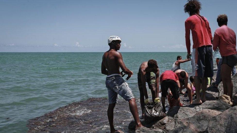 People remove crude spilled in Paulista, Pernambuco state, Brazil. Photo: 23 October 2019